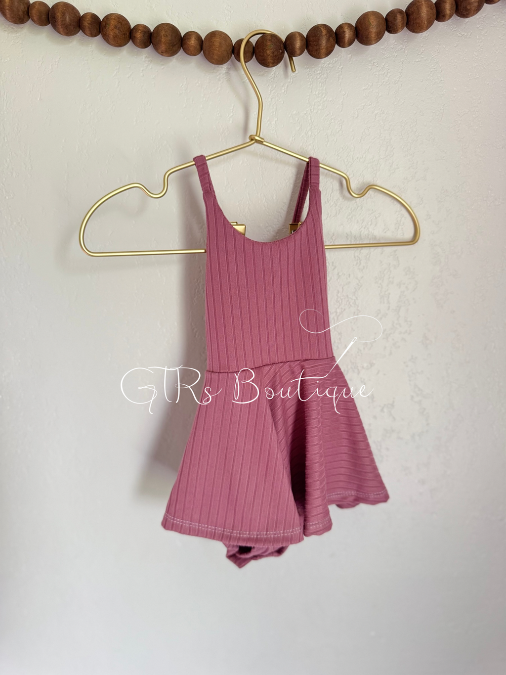 Baby skirted bodysuits with crissed crossed straps