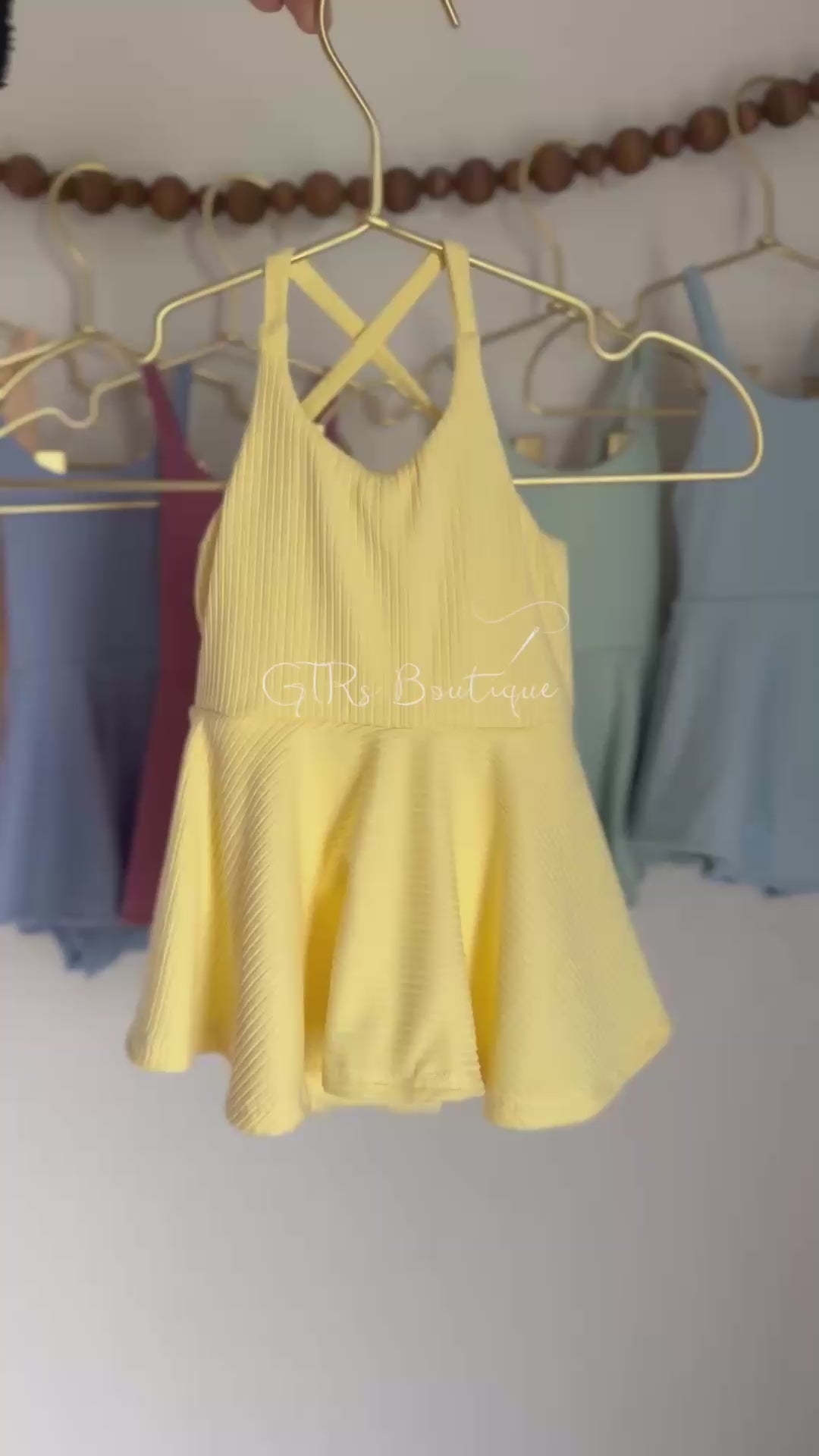 Baby skirted bodysuits with crissed crossed straps